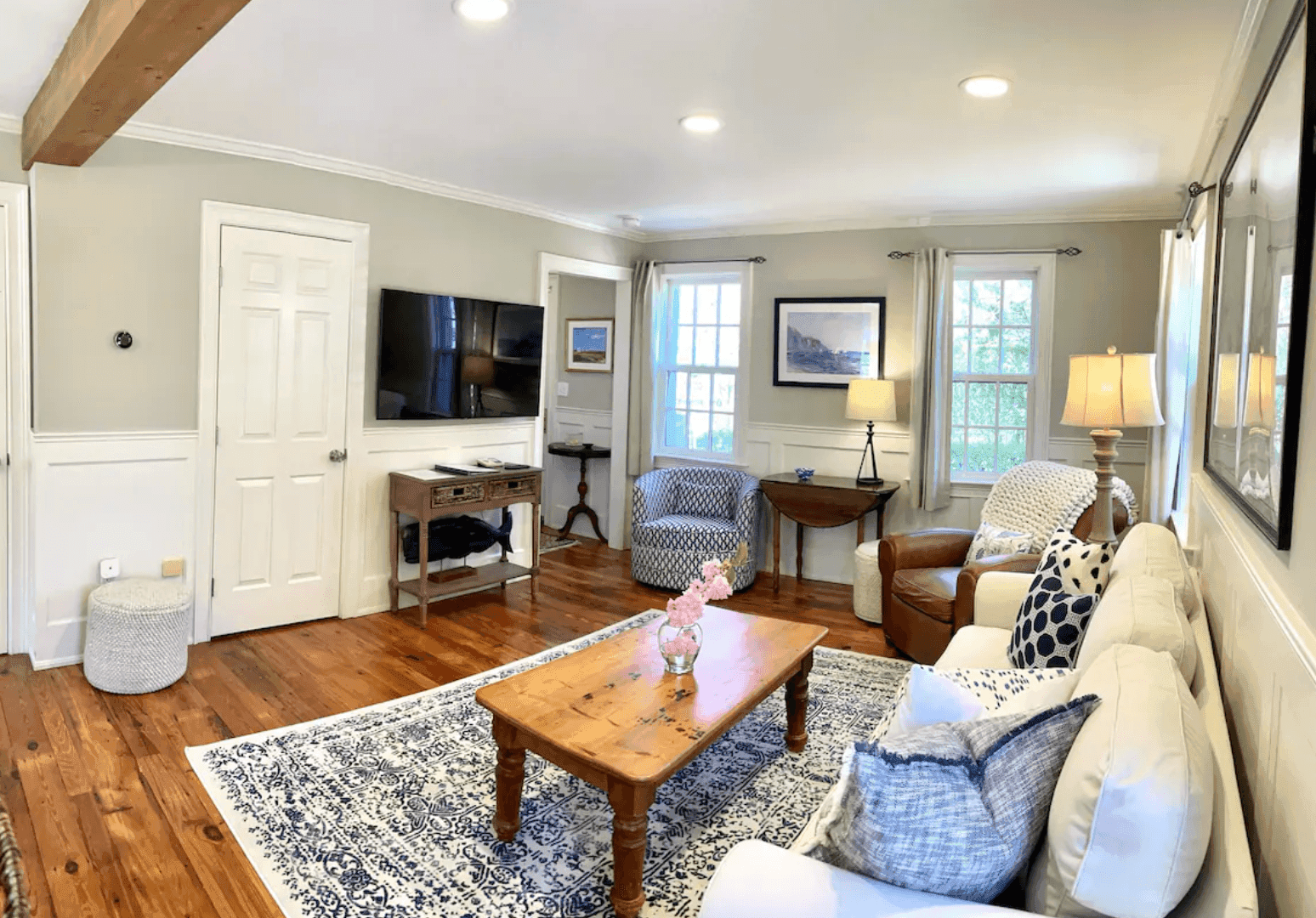 Living room with a cream sofa, blue pillows, and a whale on the console