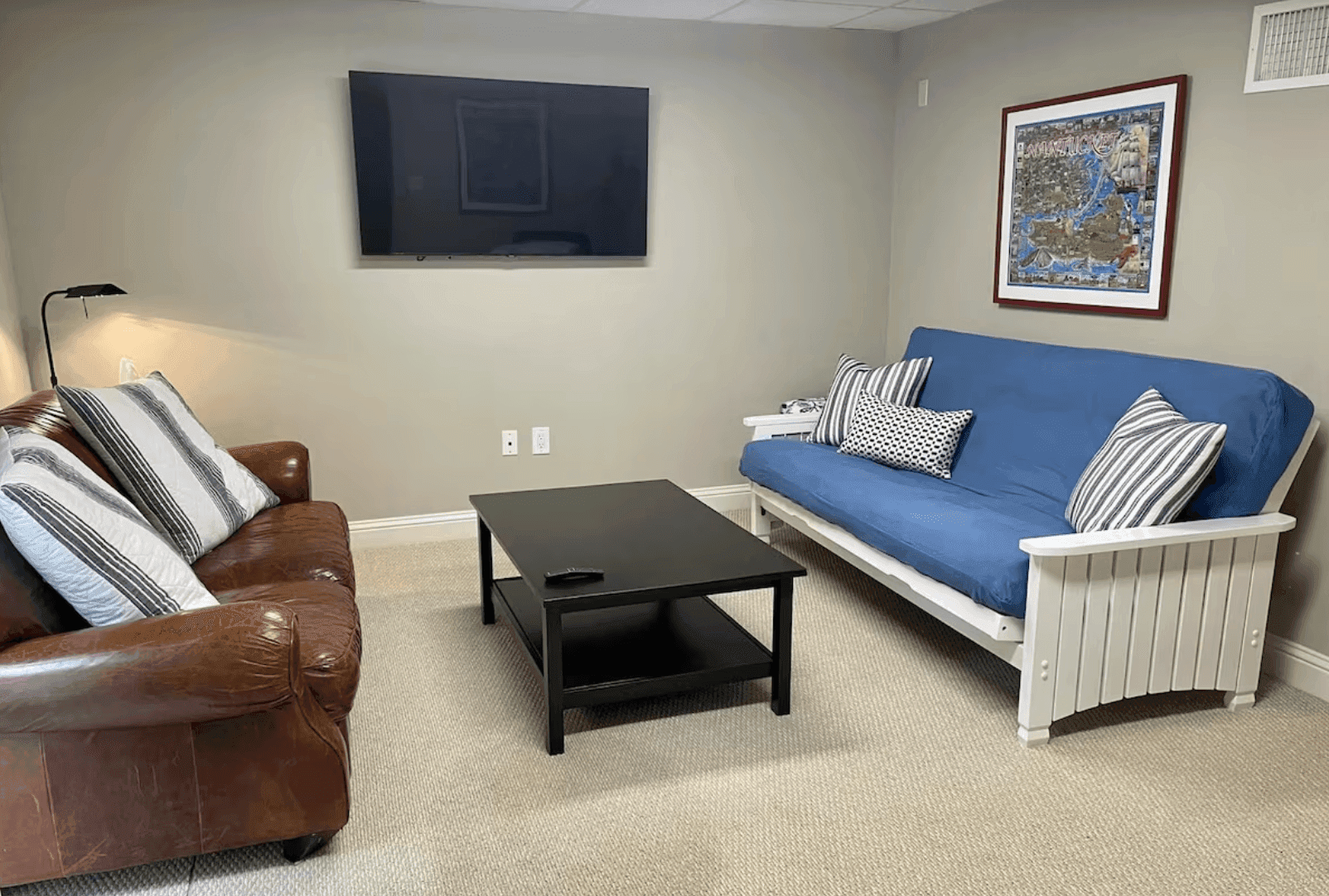 Finished basement lounge with a futon and television
